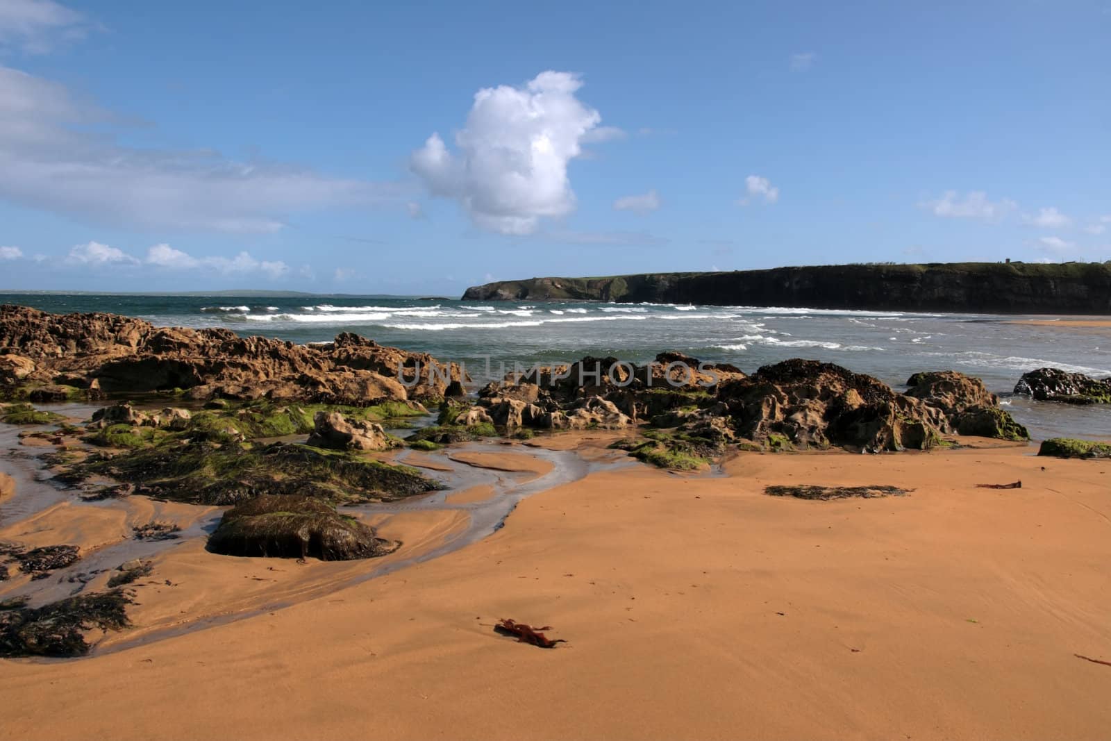 a rocky beach on a warm day with a calm sea an ideal place to have a walk in ireland