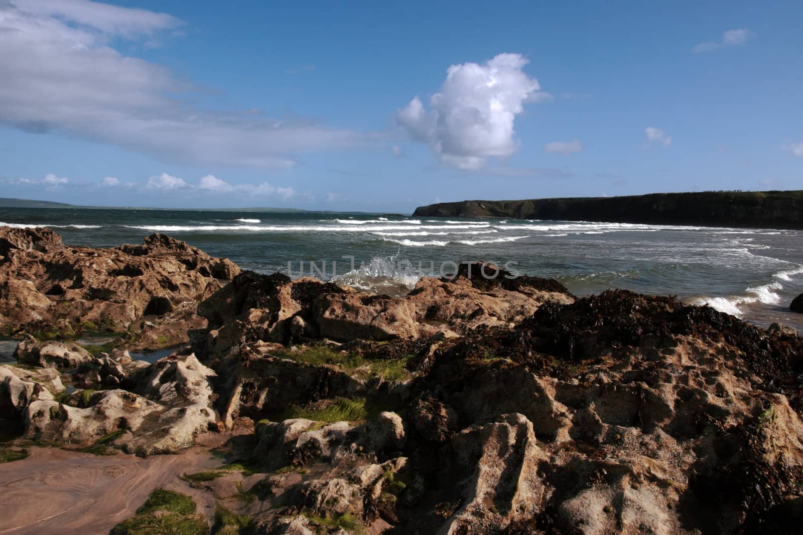 a rocky beach on a warm day with a calm sea an ideal place to have a walk in ireland