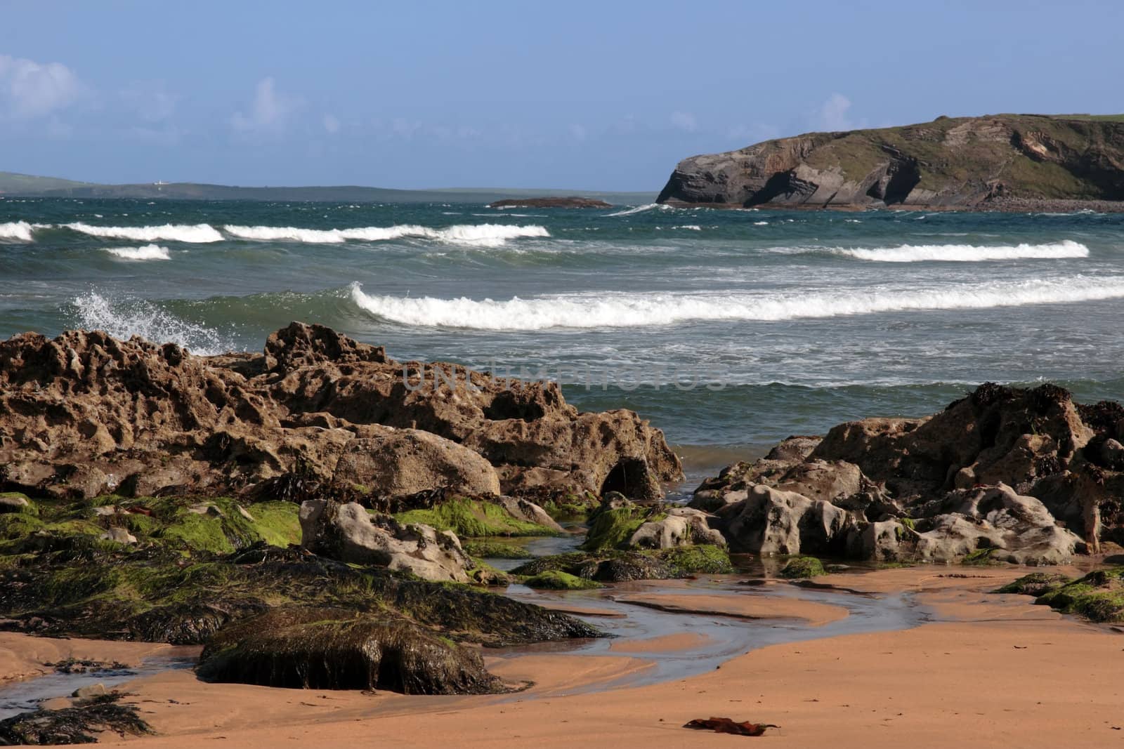 a rocky beach on a warm day with a calm sea an ideal place to have a walk in ireland