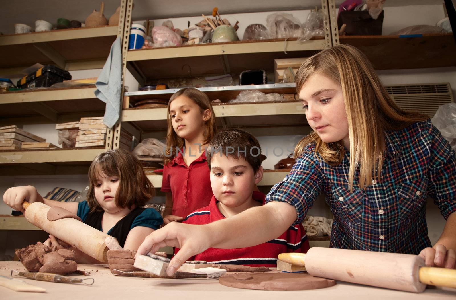 Four children working on crafts in a clay studio