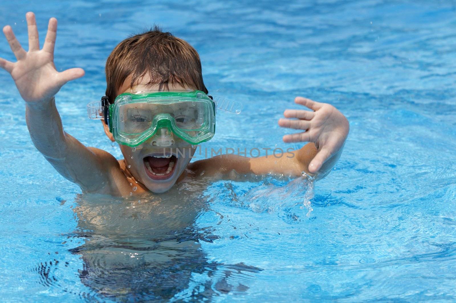 a young boy in pool with goggles on