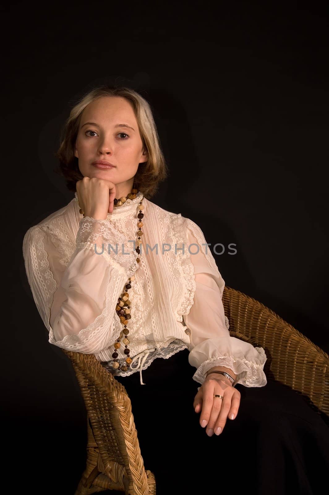 Thoughtful woman sitting in the armchair hang on arm by lilsla