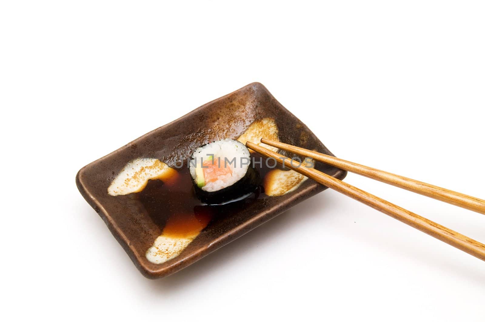 Salmon roll with avocado in soy isolated om white