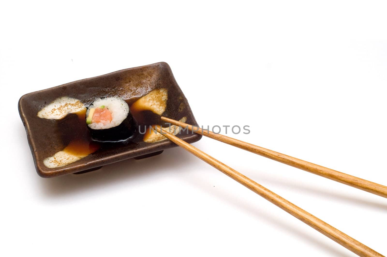 Salmon roll with avocado on plate with chopsticks by lilsla
