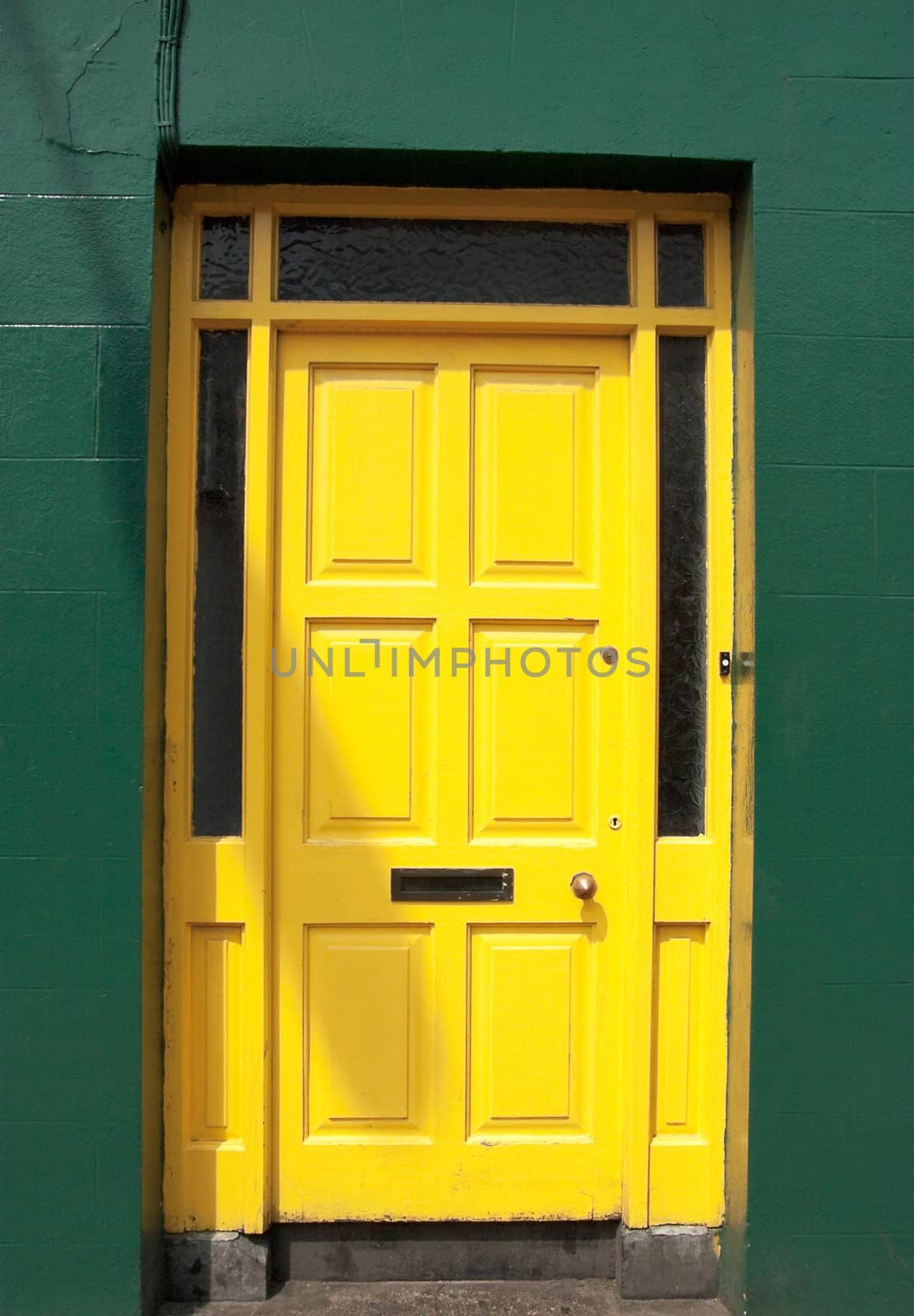 yellow door set in a frame of a green wall