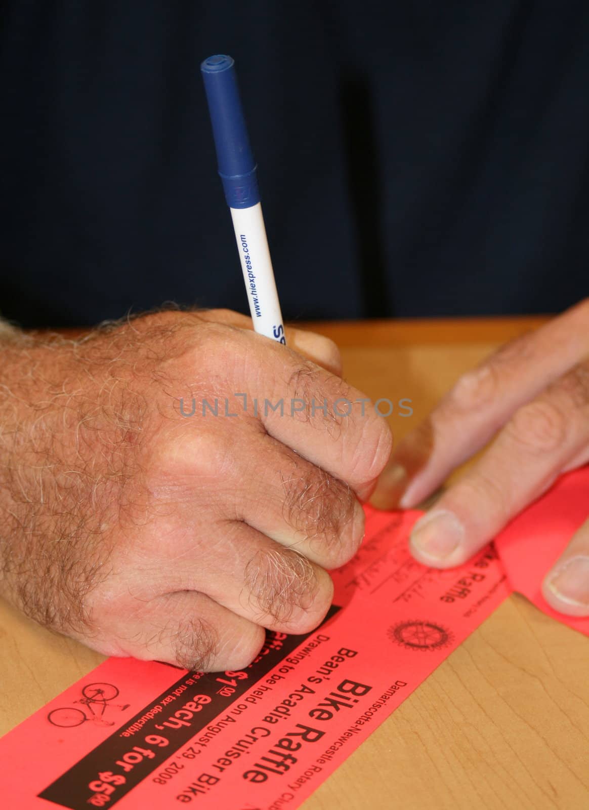 a man signing raffle tickets for a drawing
