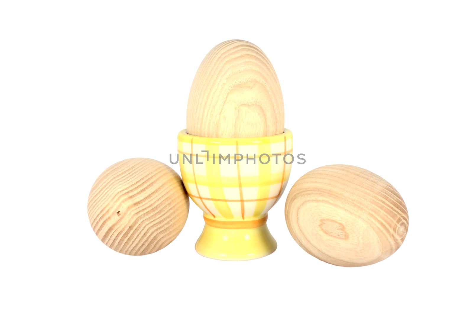 Wooden egg on the pedestal with two beside, isolated on white