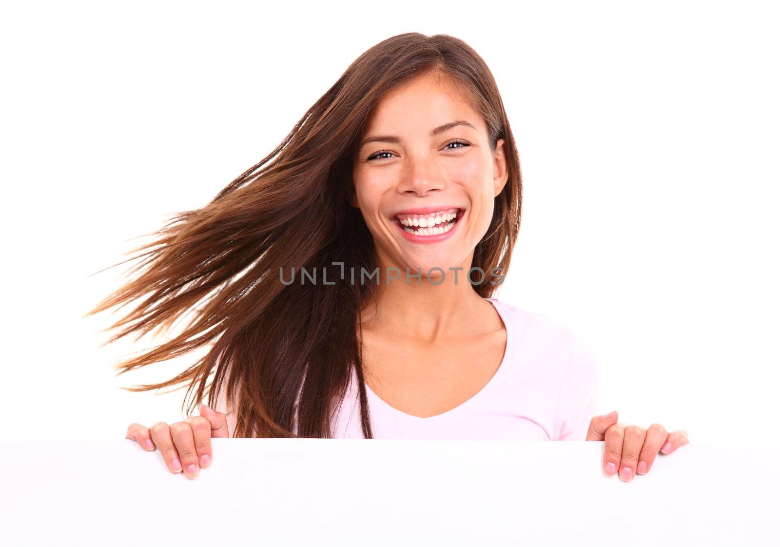 Beautiful woman holding sign. Dynamic image of woman standing behind and holding a white blank board / placard. Beautiful mixed race chinese / caucasian model. Isolated on white background.