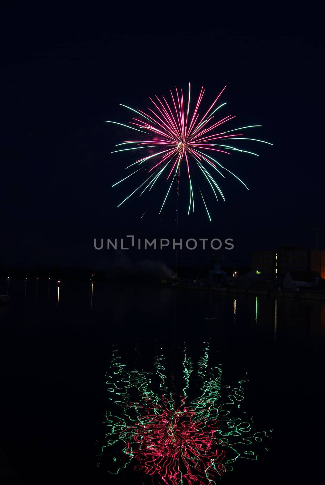 Display of fireworks with a water reflection