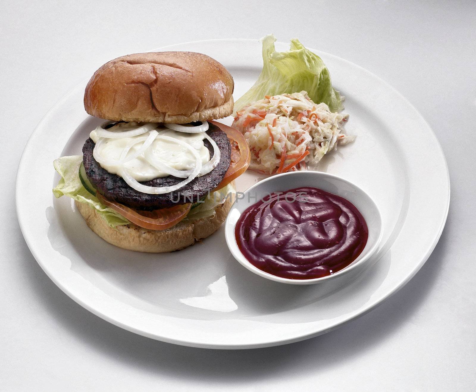 burger on the white plate with salad