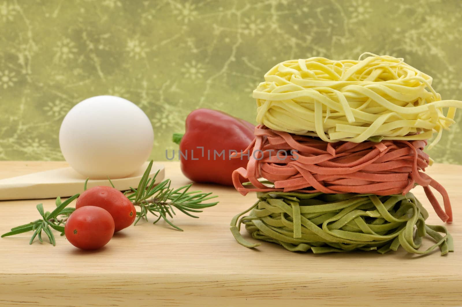 Fresh Italian pasta nests with red pepper, tomatoes, egg and rosemary ready to cook