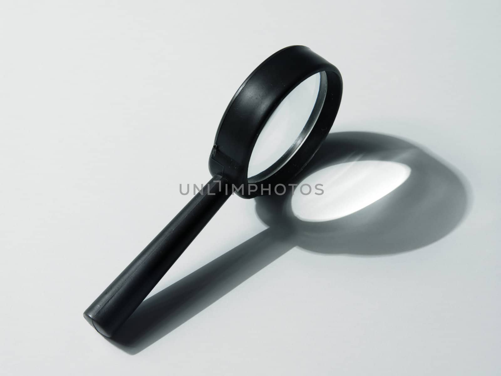  close up of the magnifying glass on the plain background