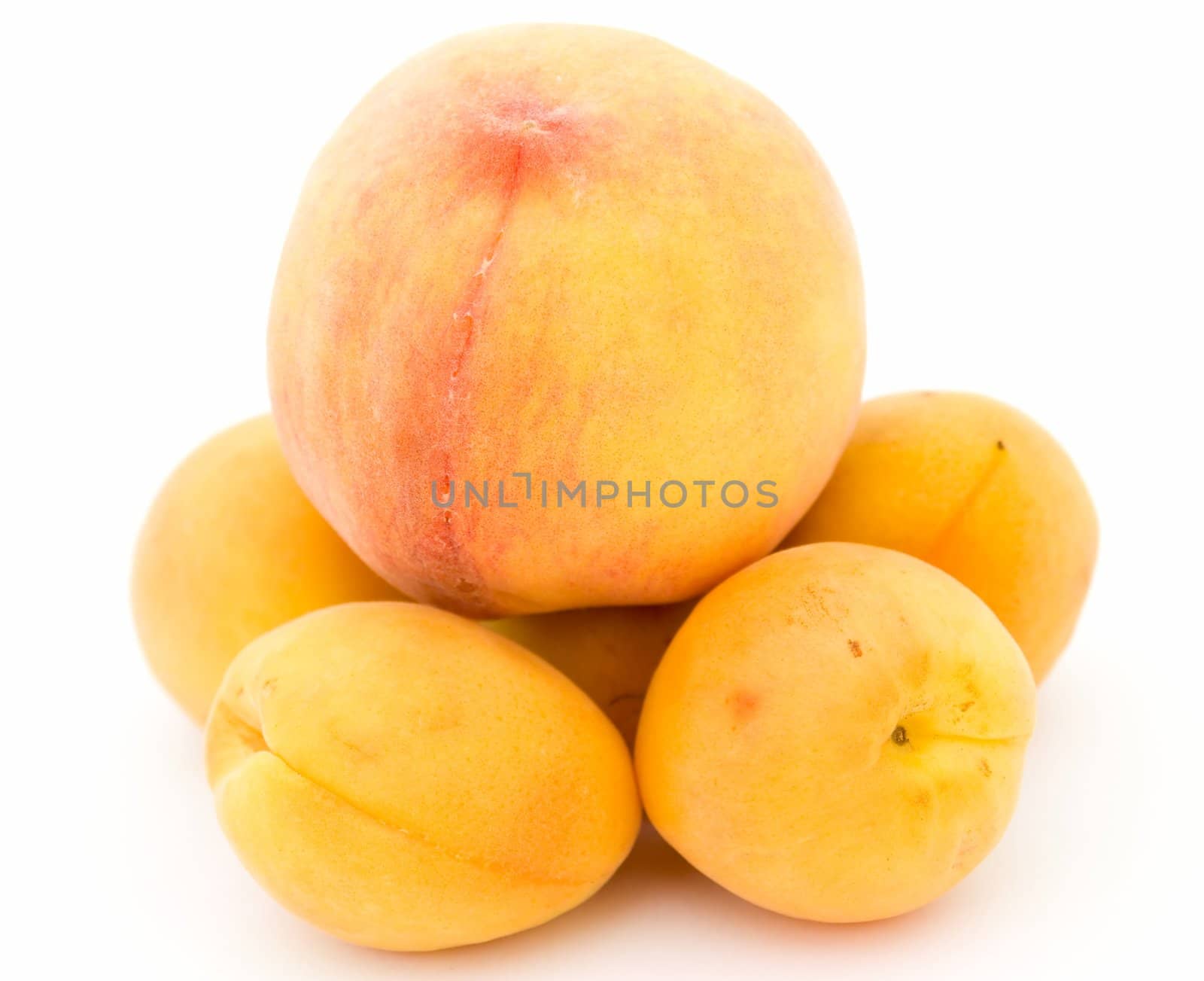 Some ripe apricots and peach on on a white background