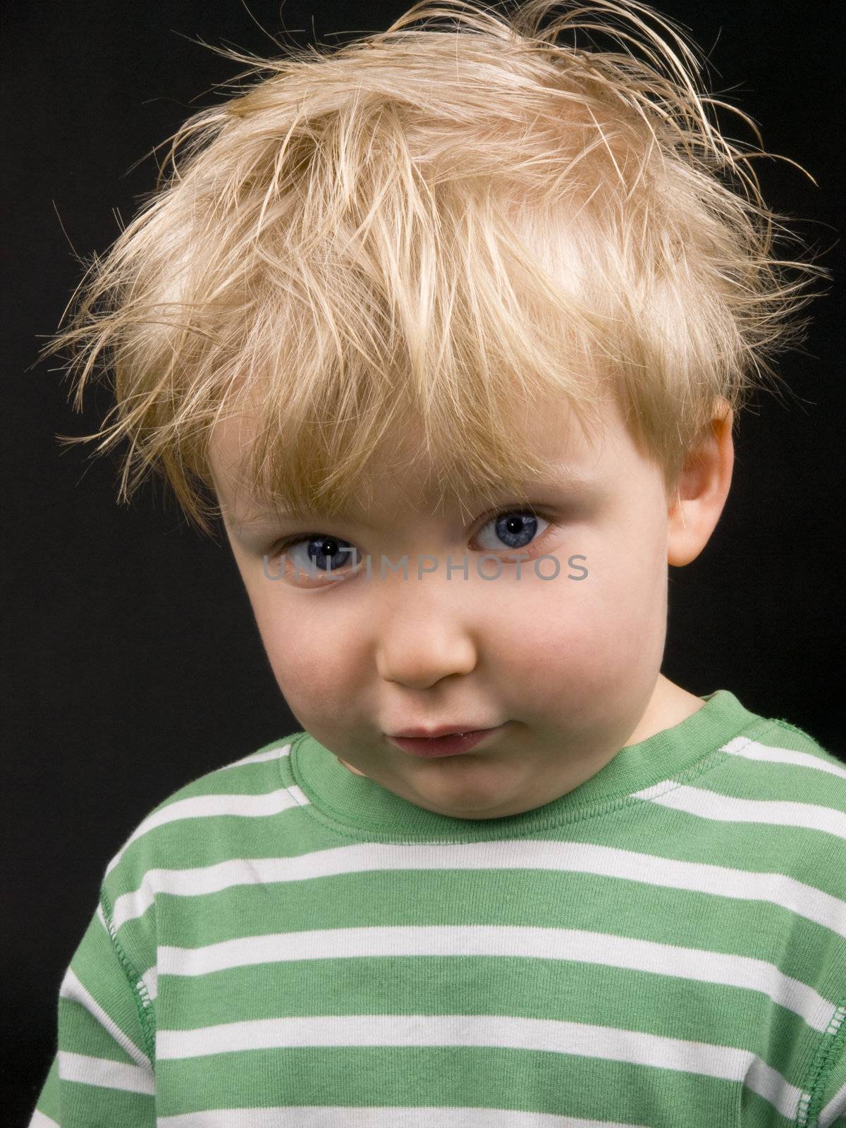 Little boy on black background. Boy have blue eyes, blond hair and a bit of dirt on his face