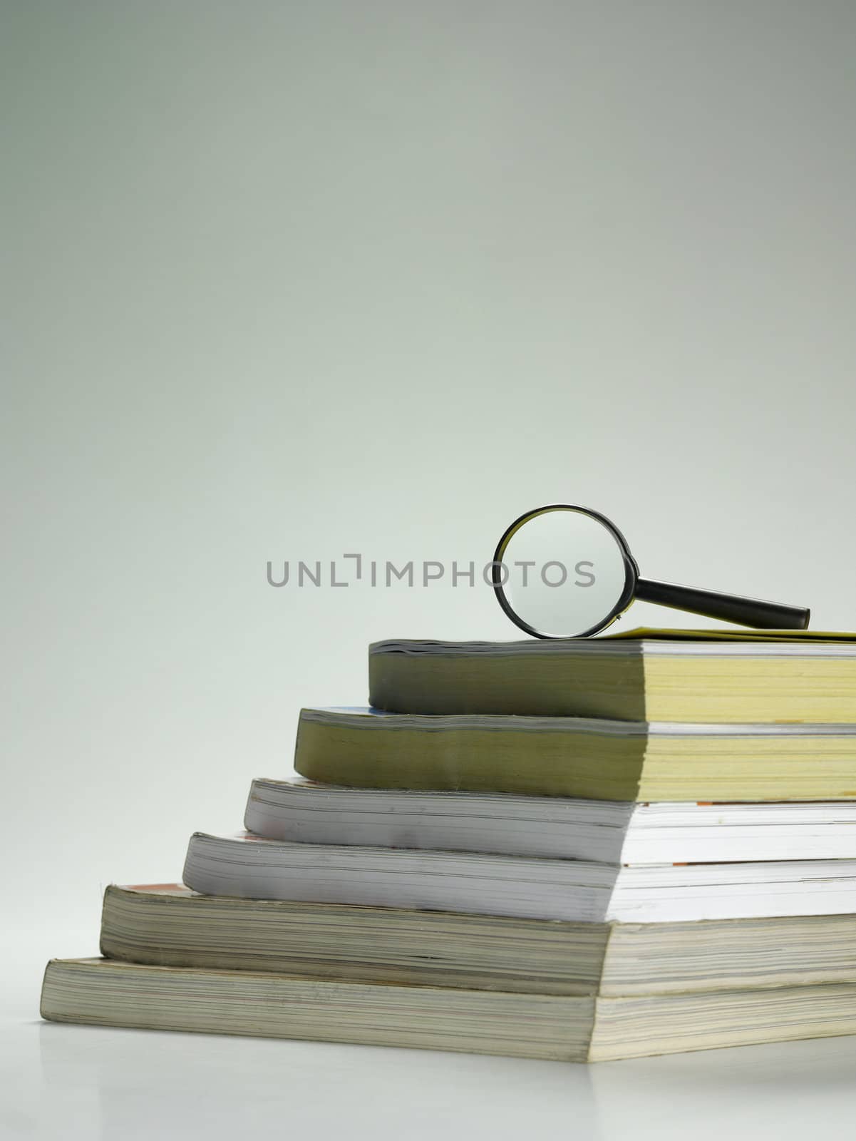 stack of books and magnifier by eskaylim