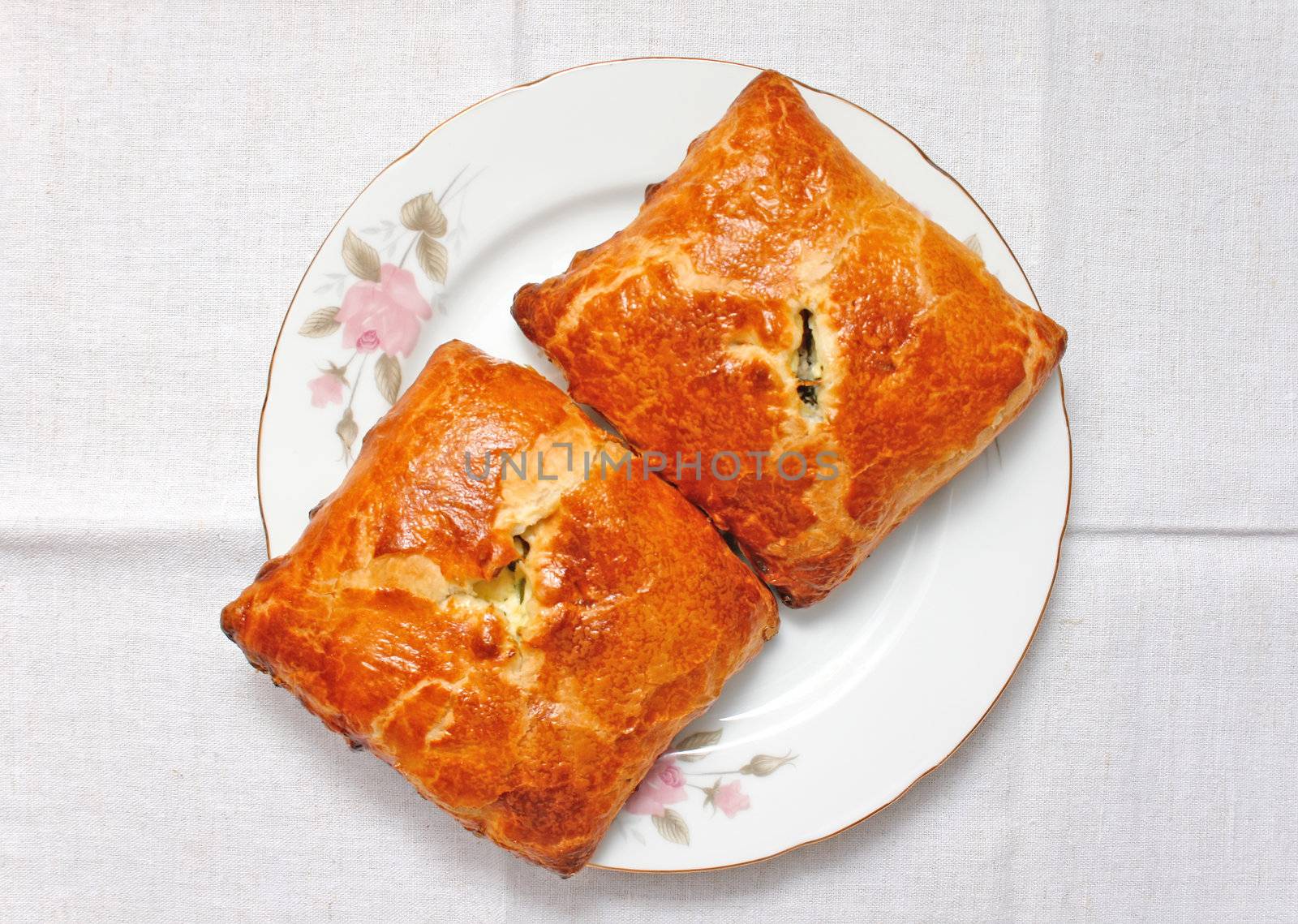 two rosy fresh pies with filling on a porcelain dish