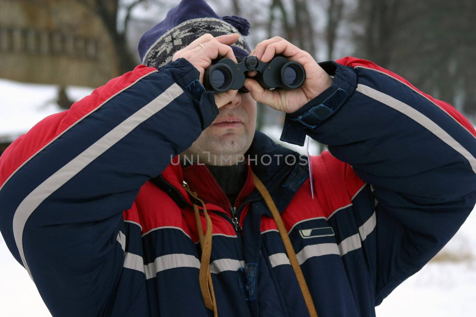 Man at winter looking with binoculars.
