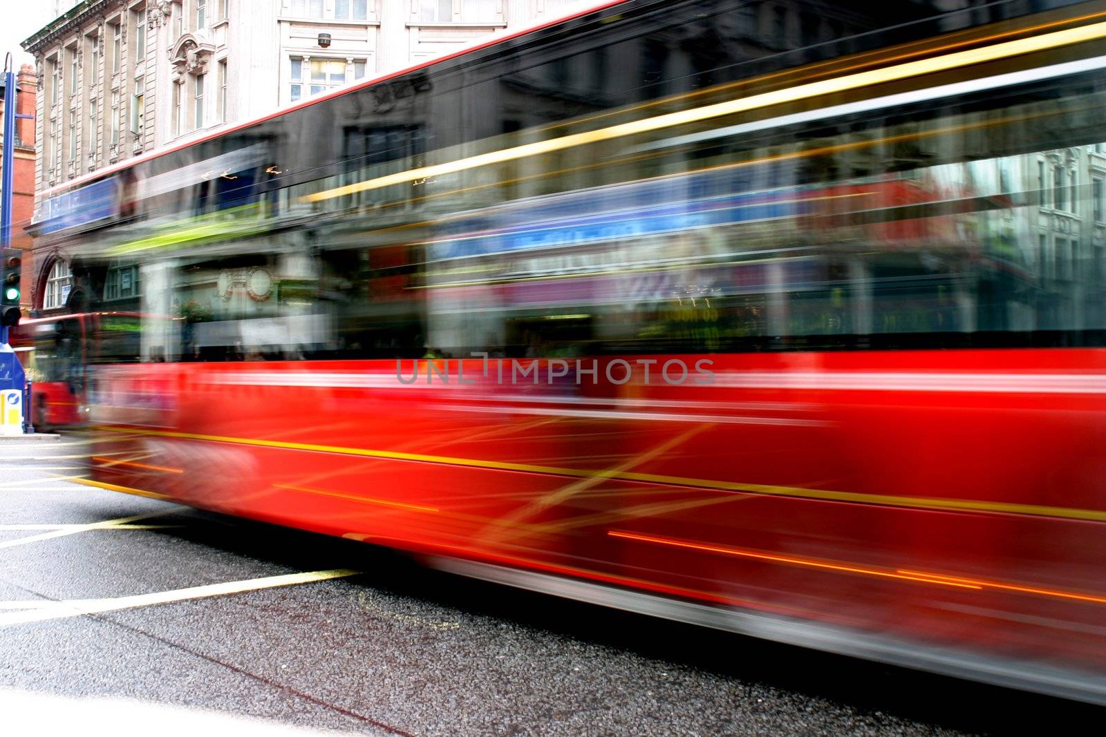 Red bus in London rushing by the camera