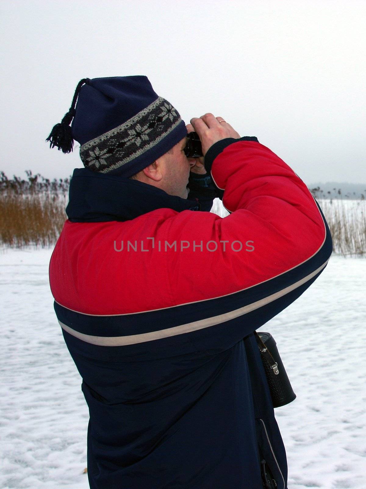 Man looking into binoculars by julien