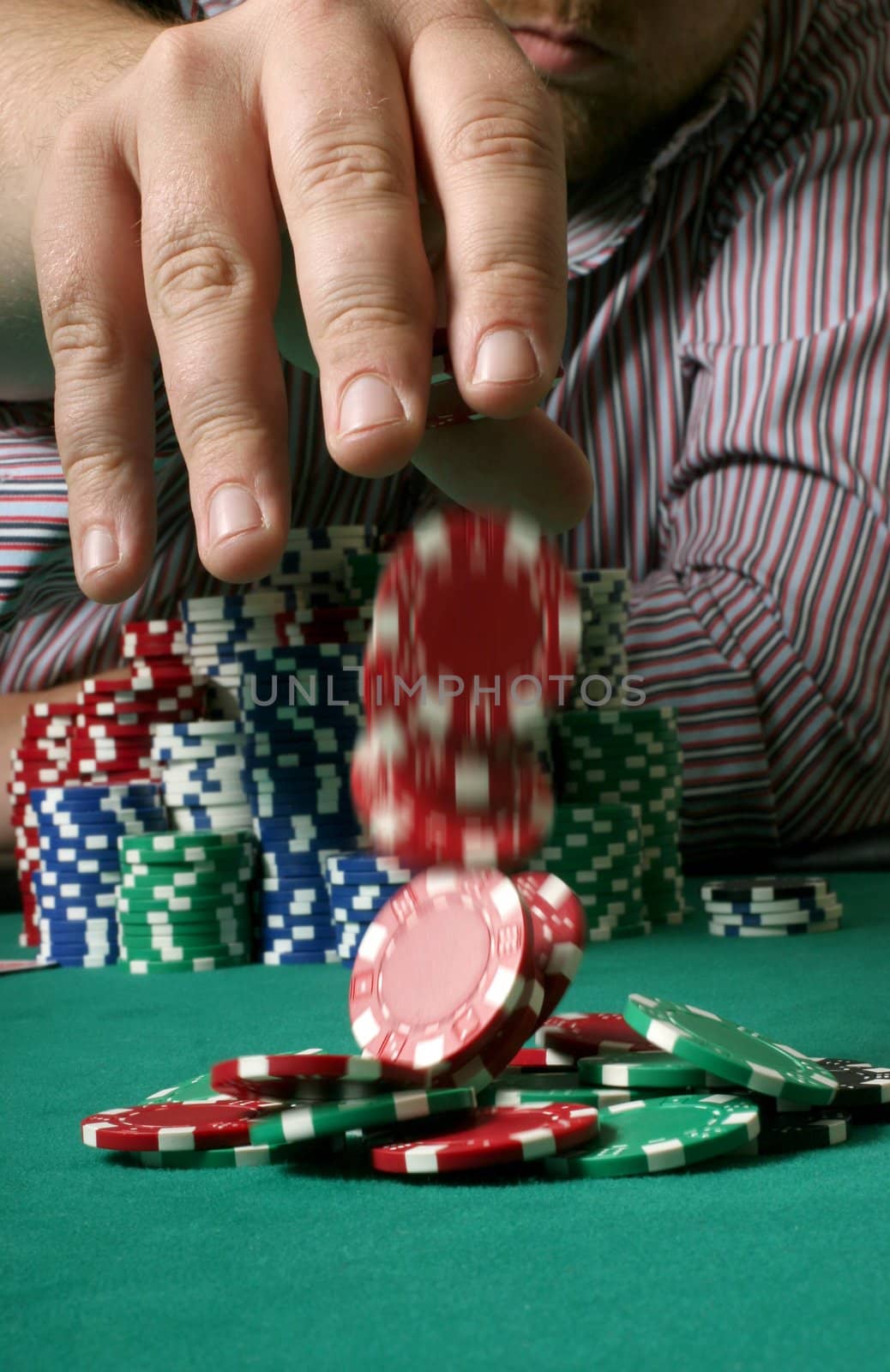 Poker player placing a confiden bet on the table - chips motion blurred