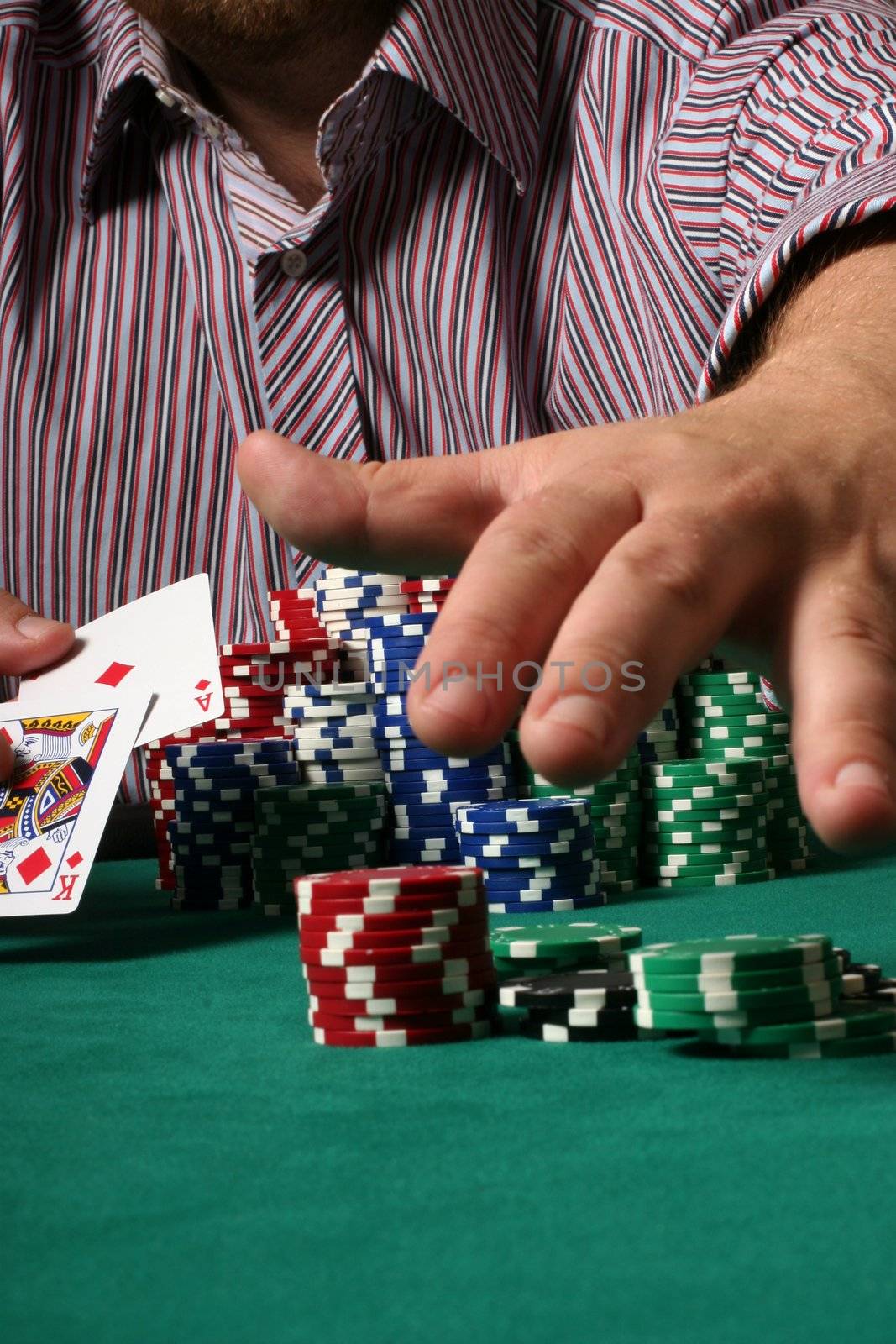 Confident poker player showing big slick and grabbing the pot