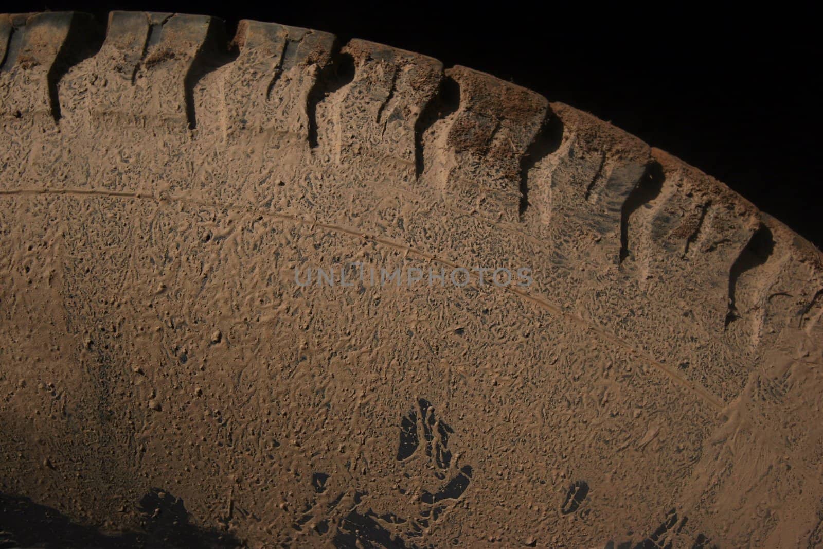 Car tire covered in dirt and mud after driving offroads