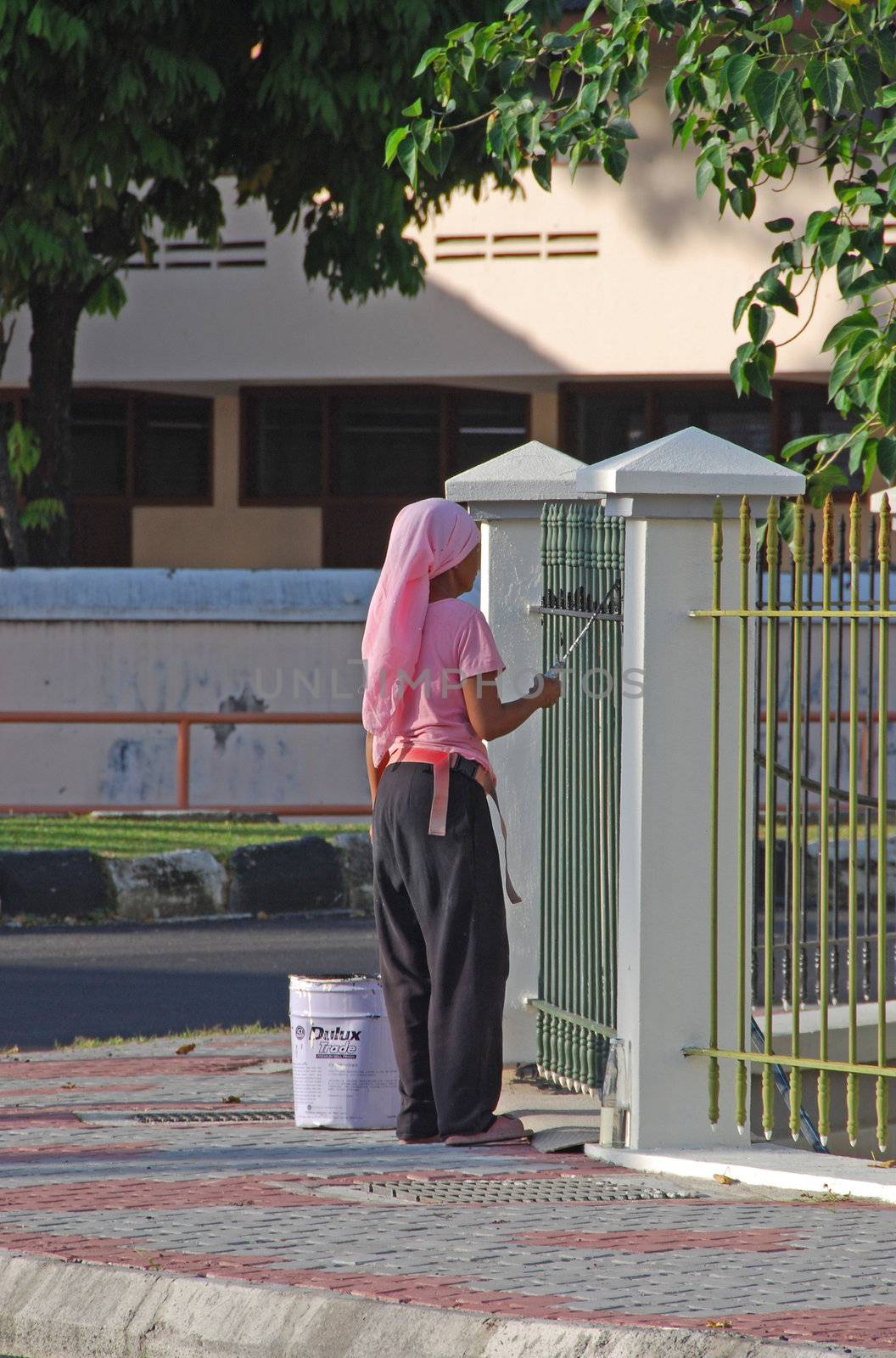 A woman painting a fence