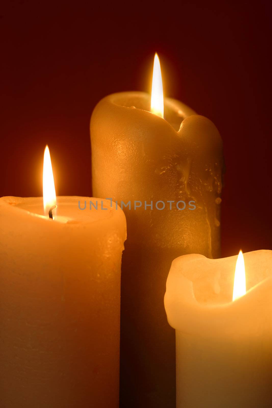 Three lit candles as a background for Christmas or religious theme.

