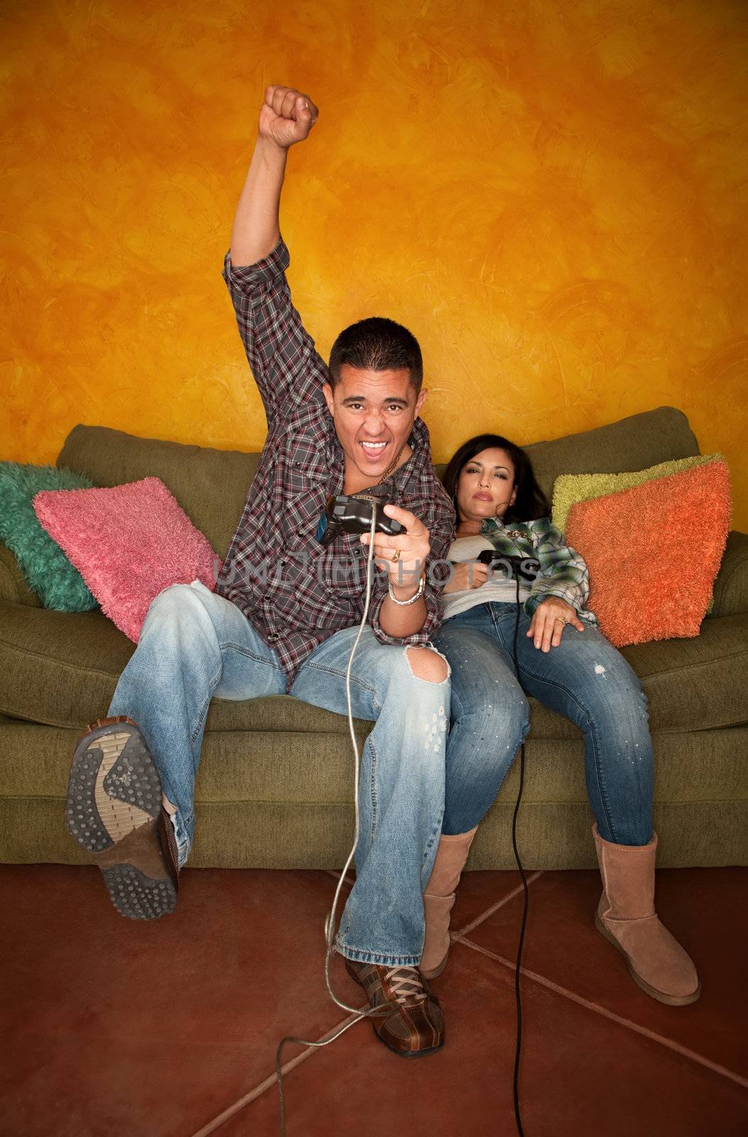 Attractive Hispanic Couple Playing a Video Game with Handheld Controllers