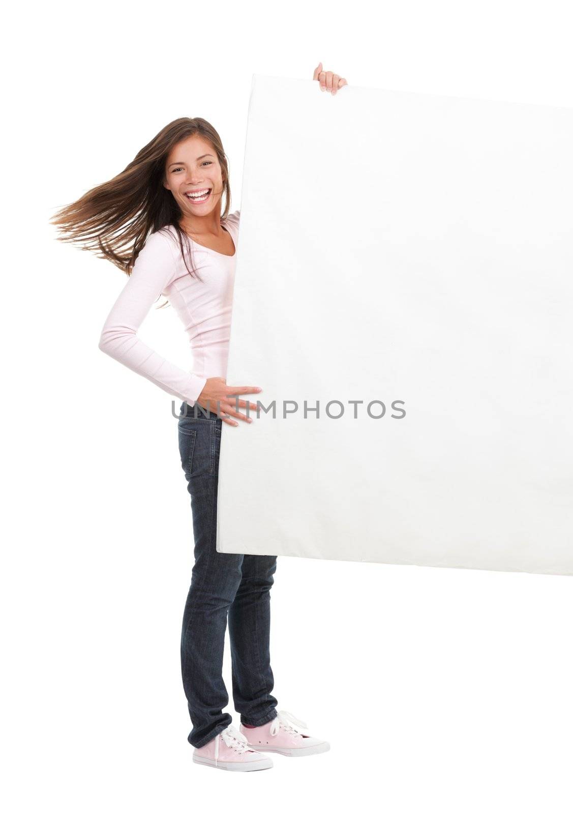 Billboard woman - beautiful young student woman holding sign. Dynamic full length image of woman holding a white blank board / placard. Beautiful mixed race asian / caucasian model. Isolated on seamless white background.