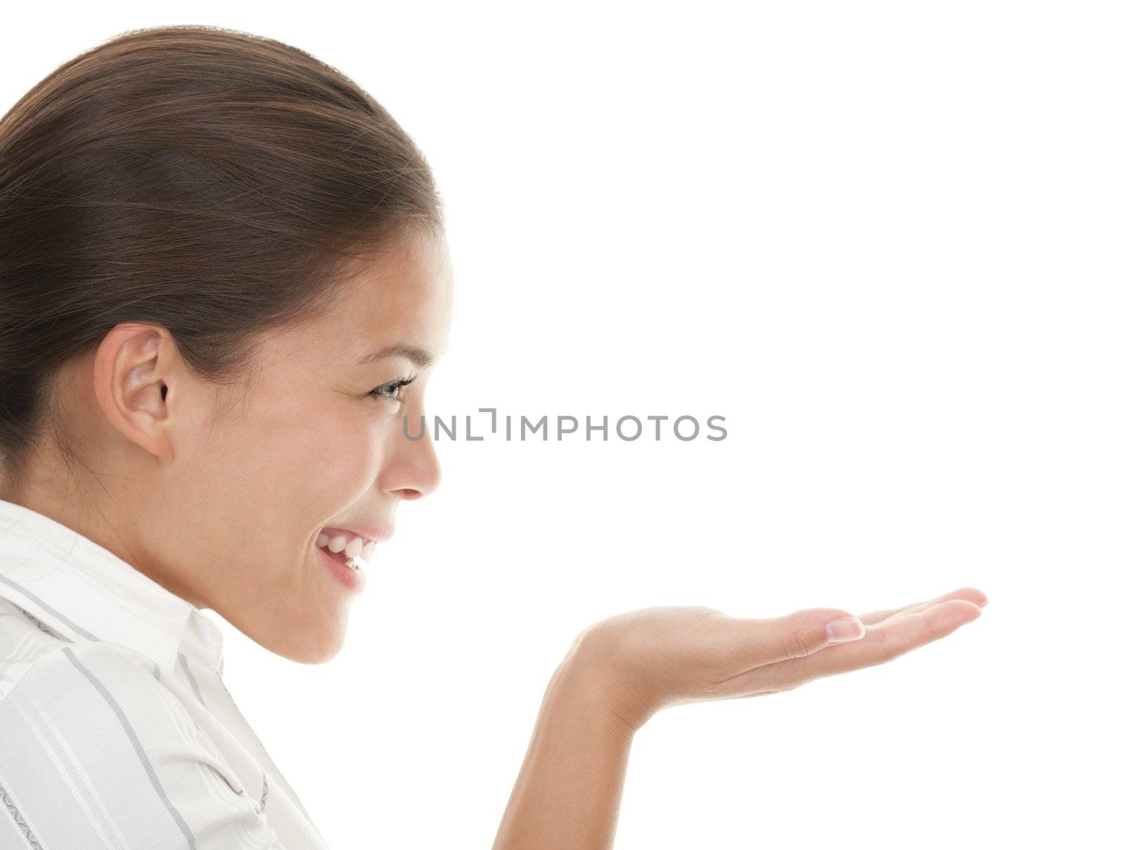Woman showing your product and looking at her open hand / palm. Gorgeous adorable young mixed race chinese / caucasian businesswoman isolated on seamless white background. 
