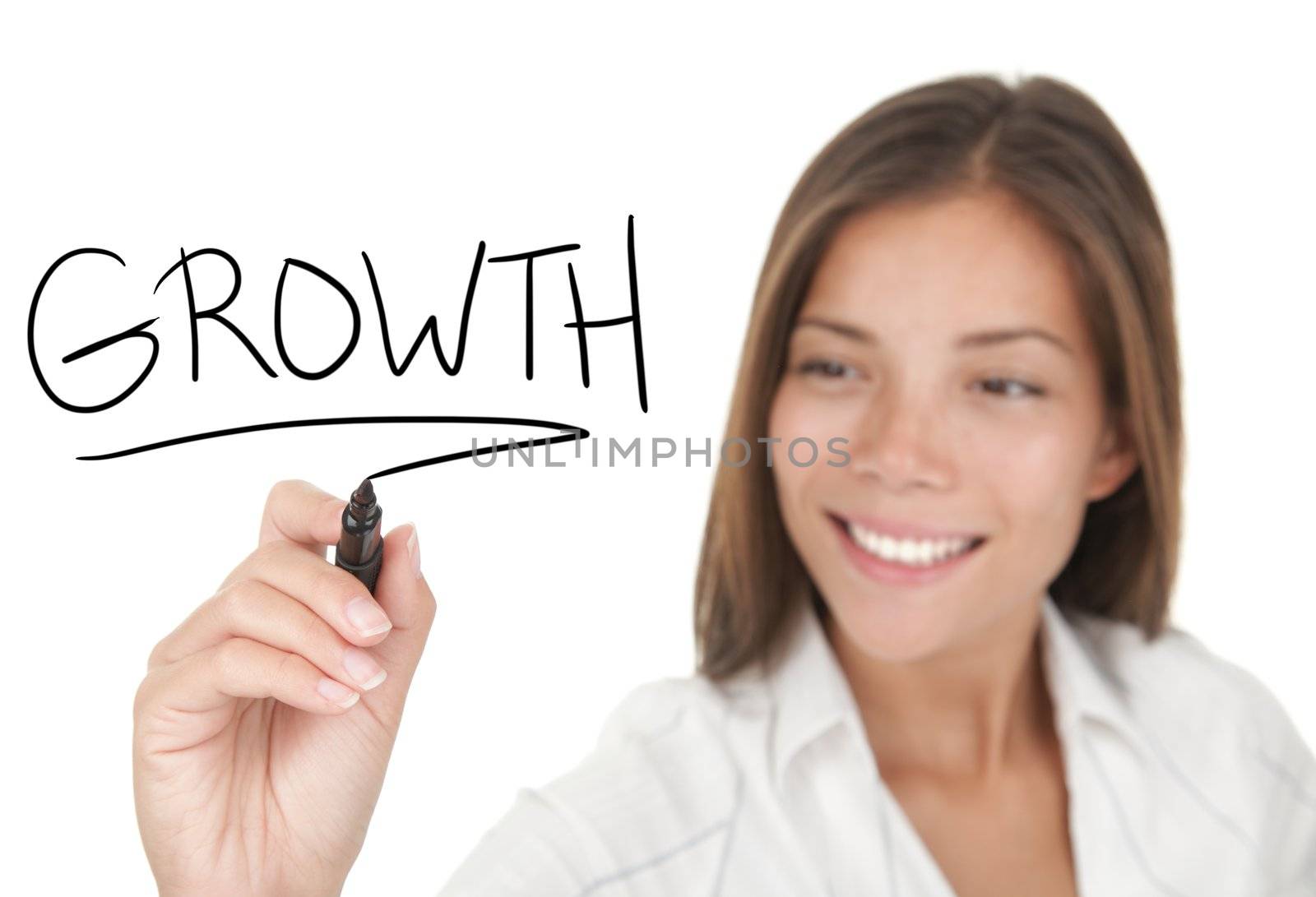 Growth and success in business concept. Young beautiful businesswoman with pen writing growth on whiteboard. Focus on the black marker. Mixed race Chinese / Caucasian model isolated on white background.  