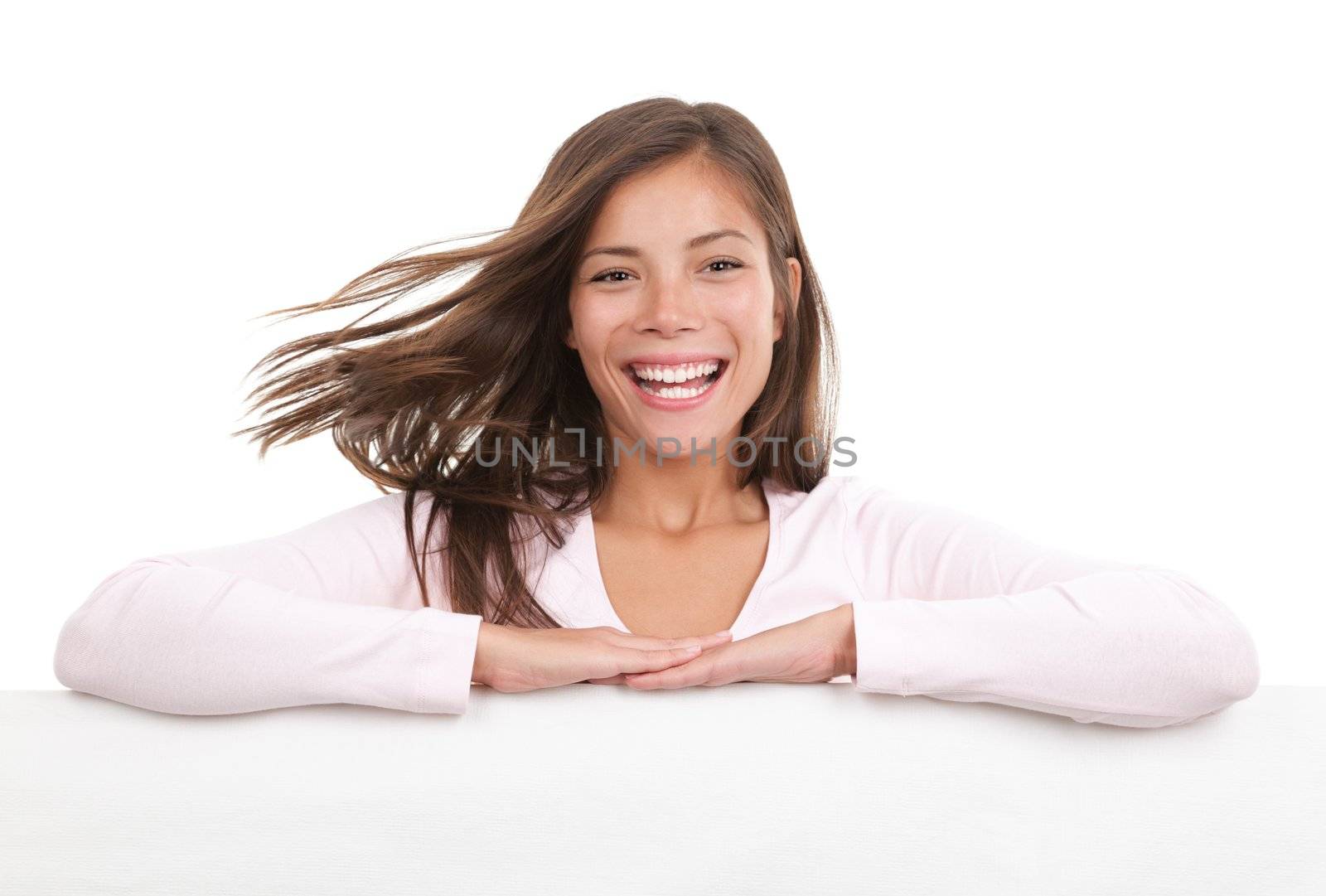 Billboard sign woman. Dynamic image of woman standing behind and holding a white blank board / placard. Beautiful mixed race chinese / caucasian model. Isolated on white background.