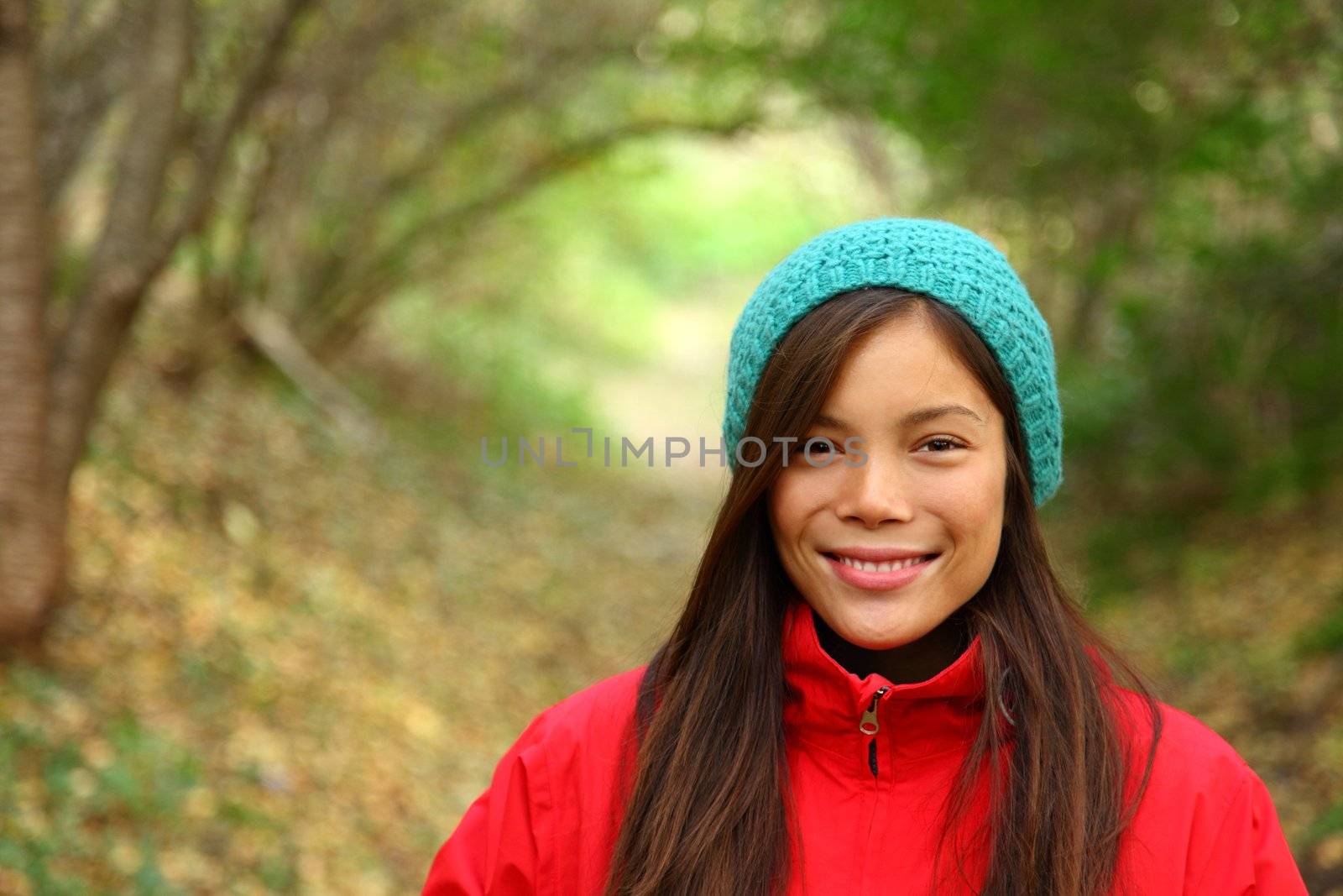  Autumn woman smiling. Beautiful woman walking in the forest on a fall day.