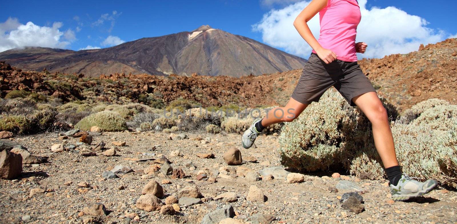 Running in spectacular volcano landscape on Teide, Tenerife. Woman in pink top.
