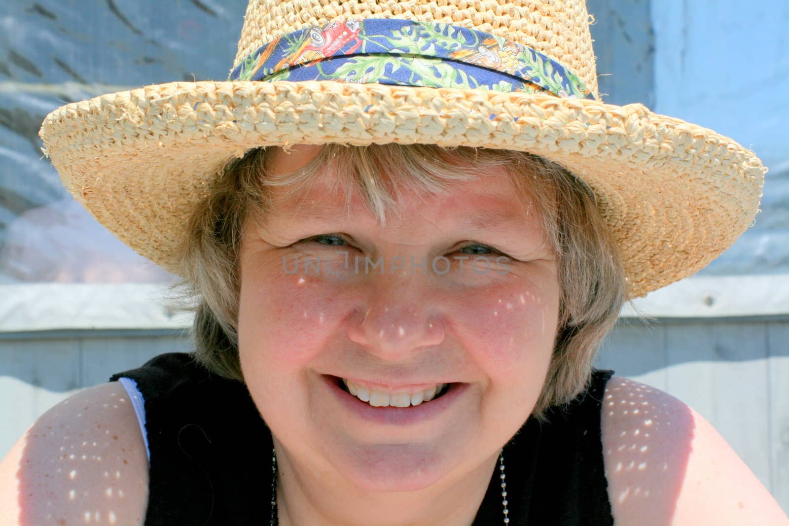 Happy woman in sun hat, avoiding sunburn 