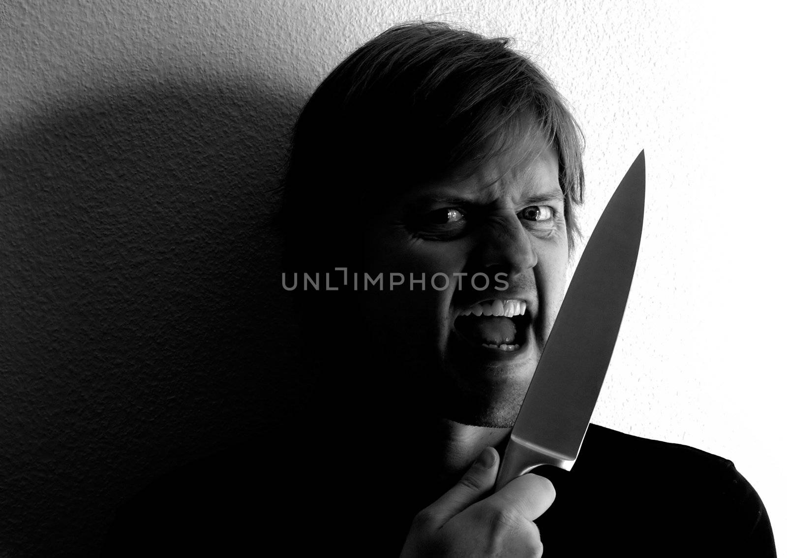 Crazy fellow wielding a knife.  Harsh lighting and shadows for more dramatic effect.
