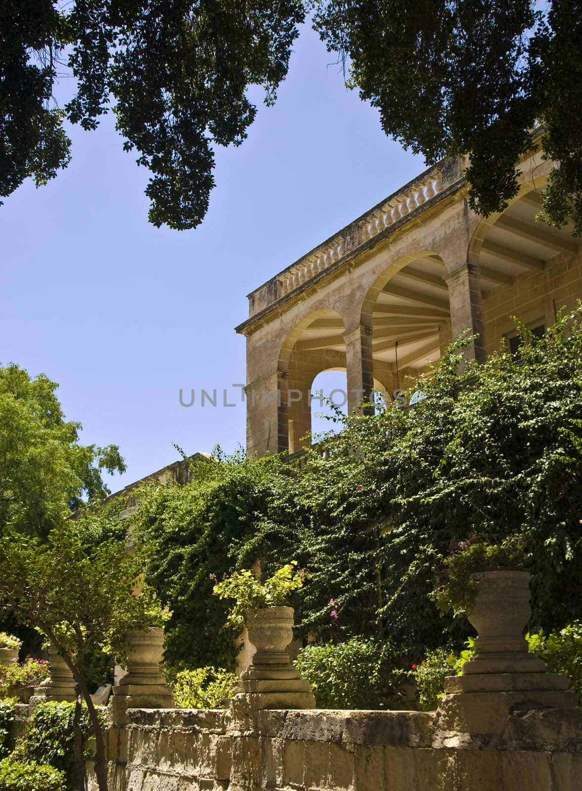 An enclosed Mediterranean balcony or terrace looking over gardens