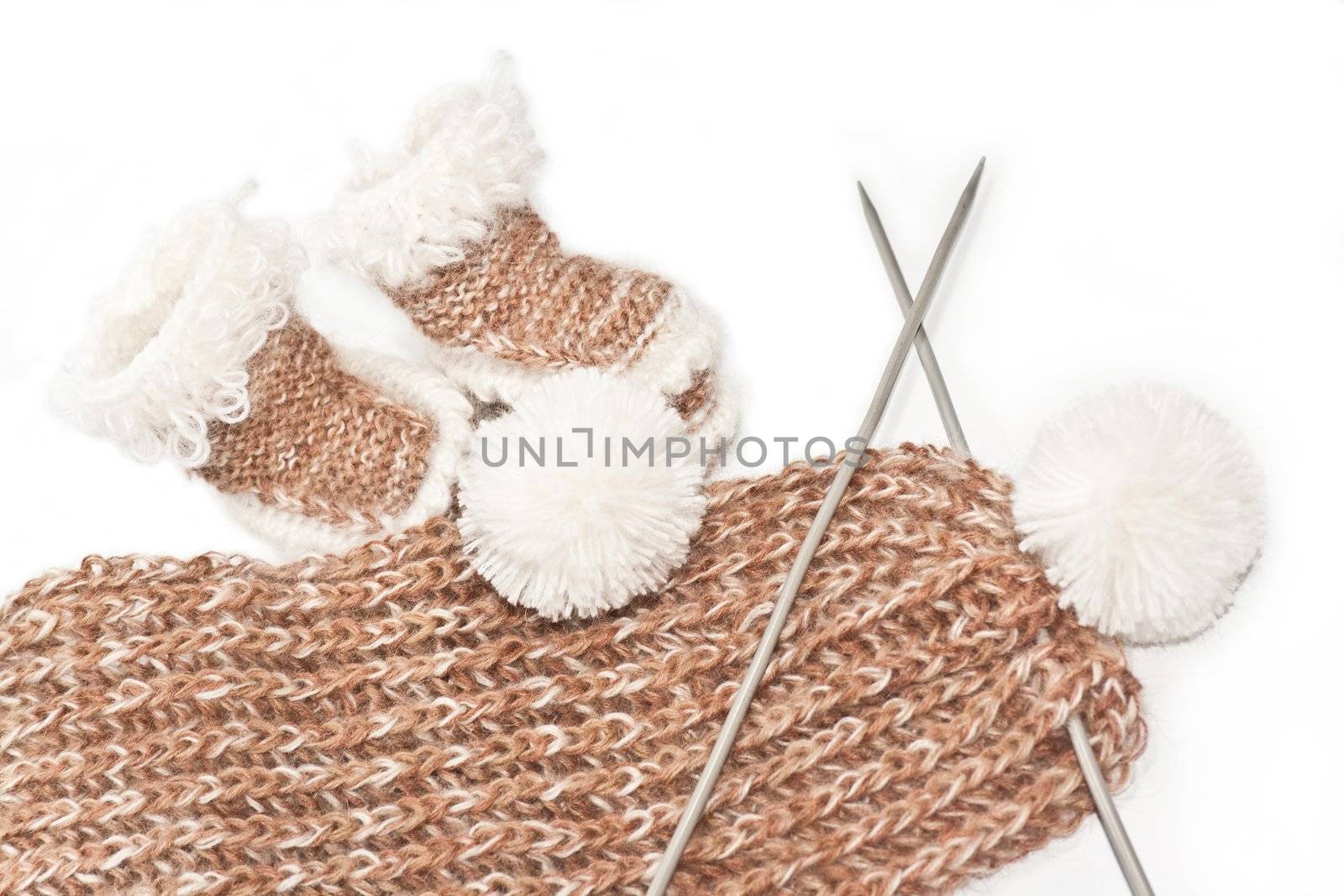 Knitted baby's bootees and a white scarf, brown for babies, toddlers