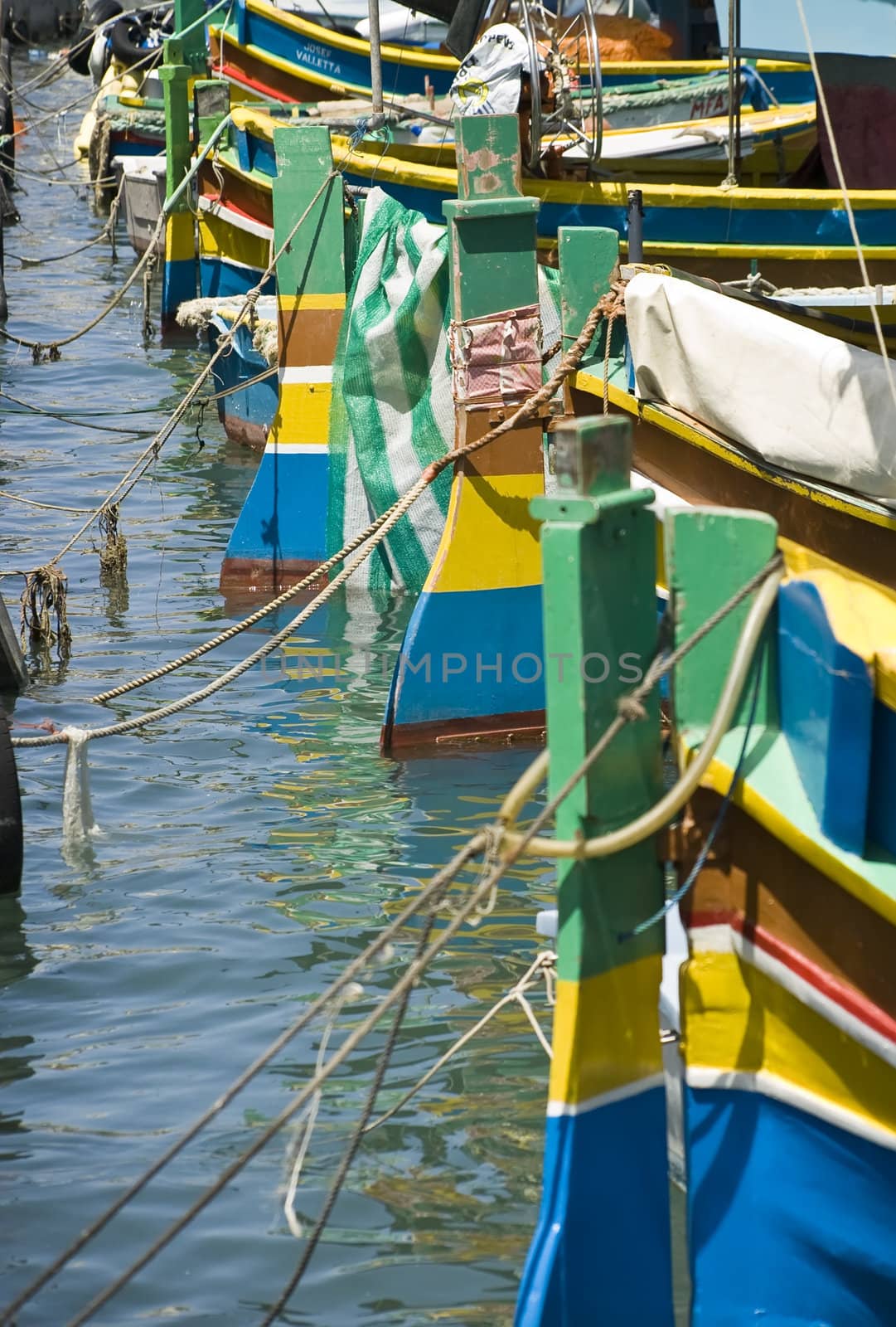Rudders of traditional fishing boats of Malta in the fishing village of Marsaxlokk lined up at quayside