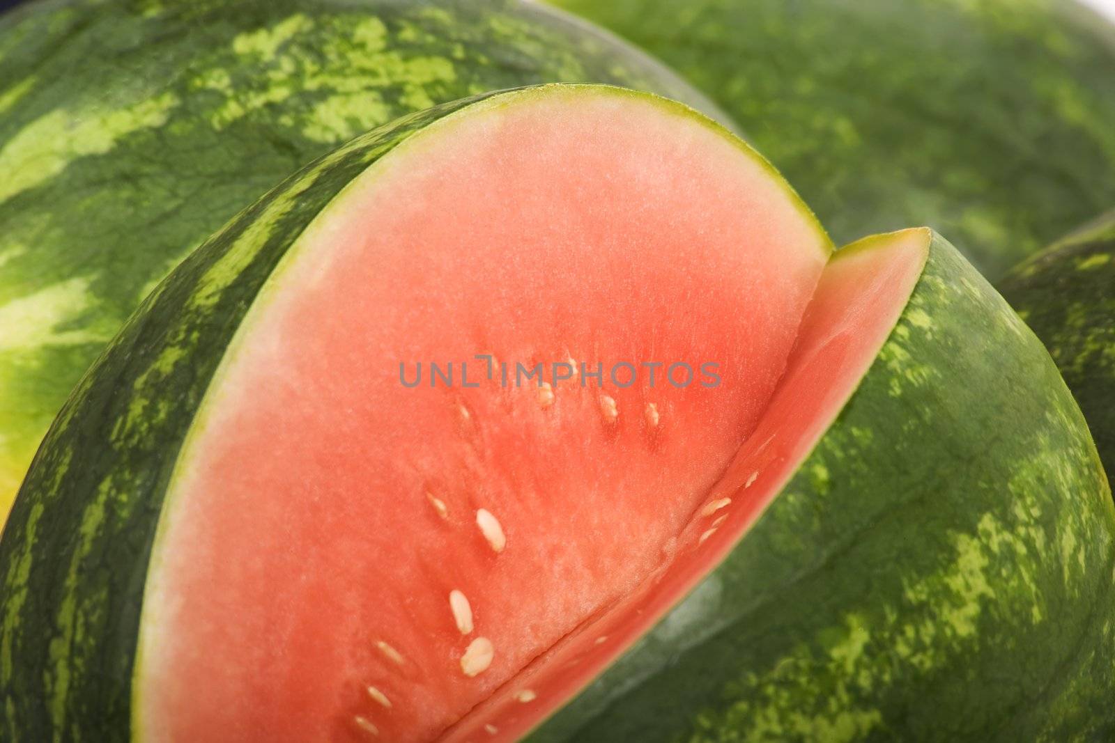 Bright red and green watermelon with a slice removed