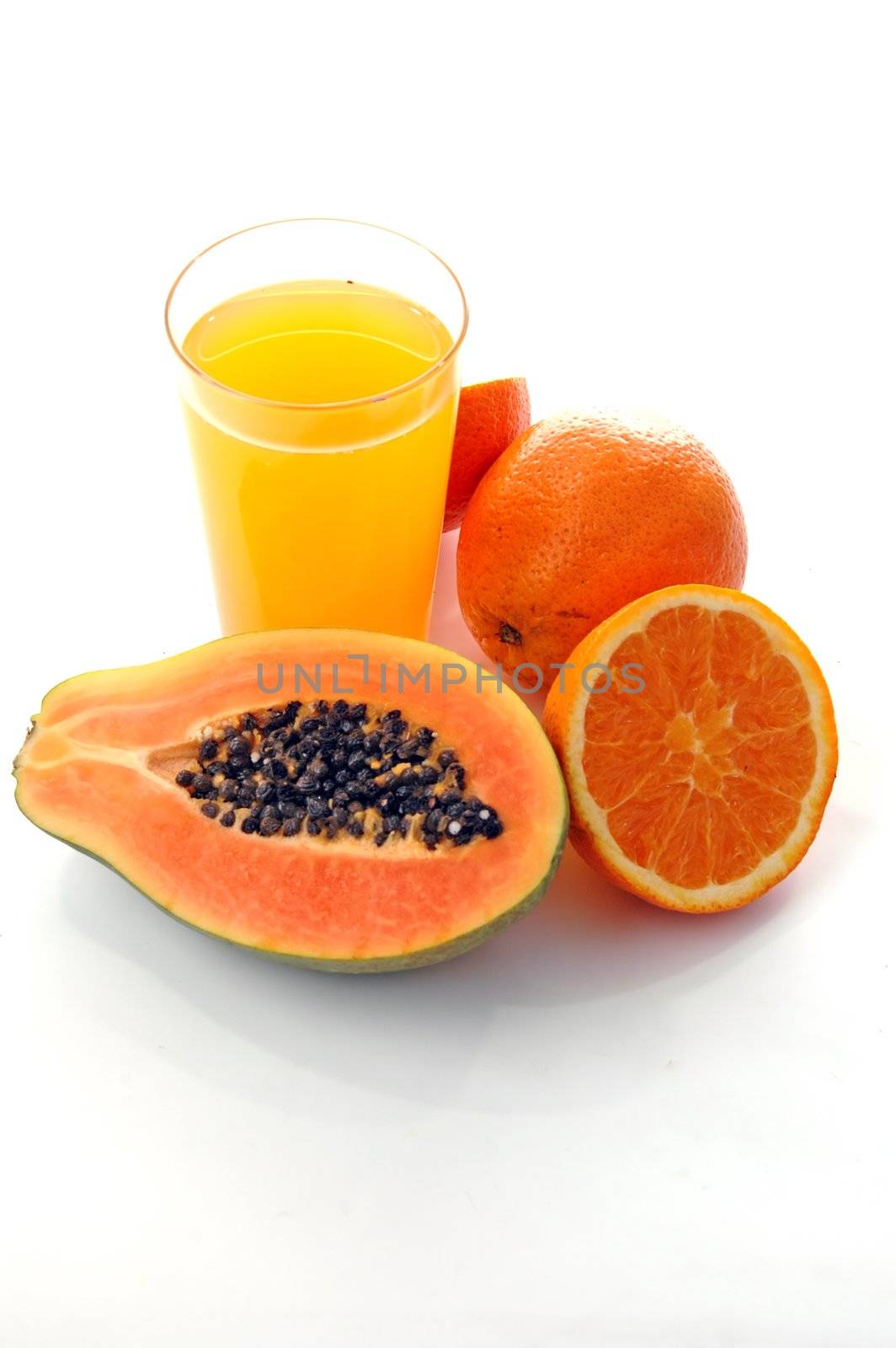 a glass of orange juice with cut oranges