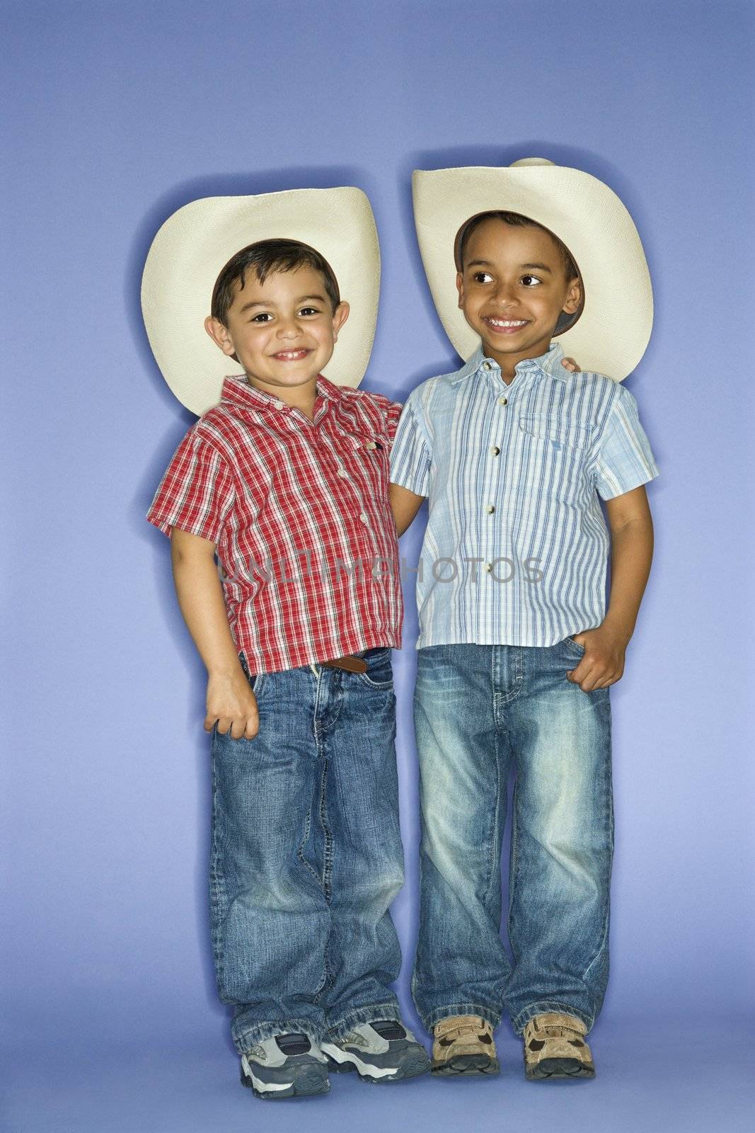 Hispanic and African American male child in cowboy hats.