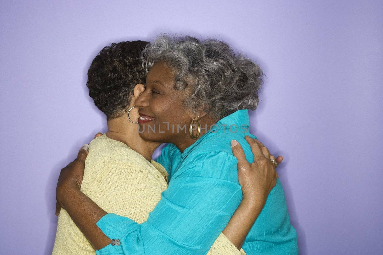 Mature adult African American females embracing.