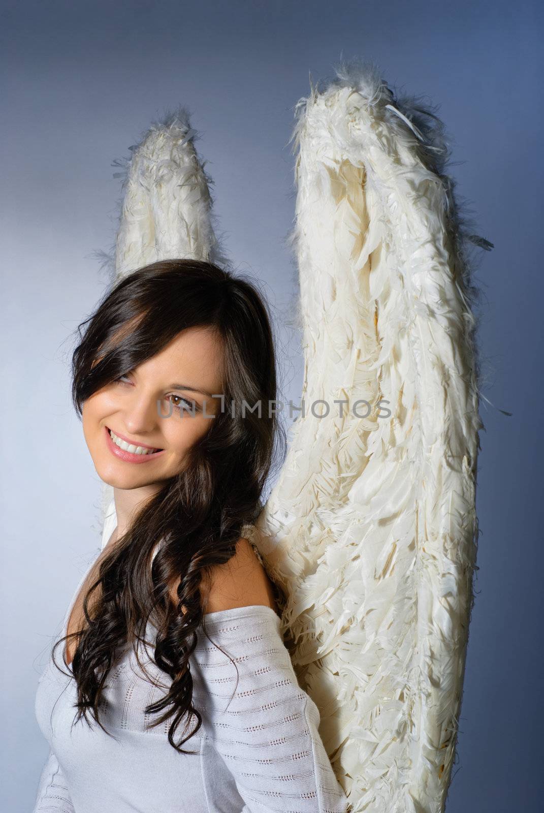 Young woman wearing angel wings smiling