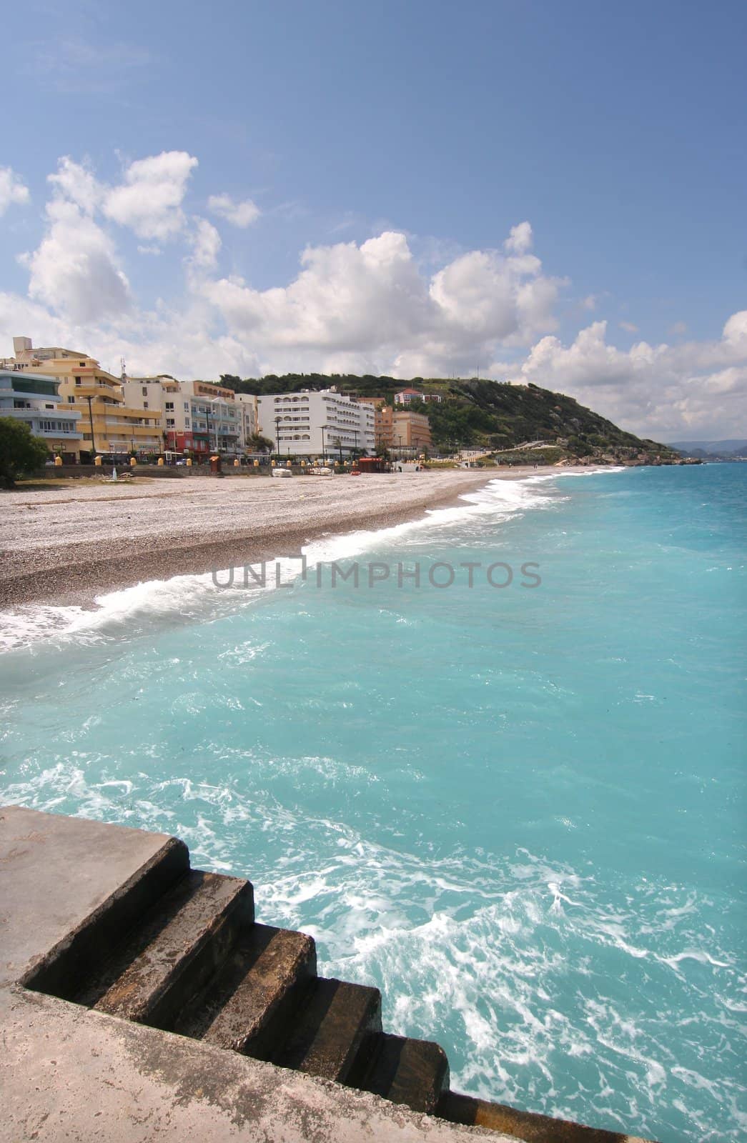 Stone jetty and hotels on the beach in Rhodes, Greece