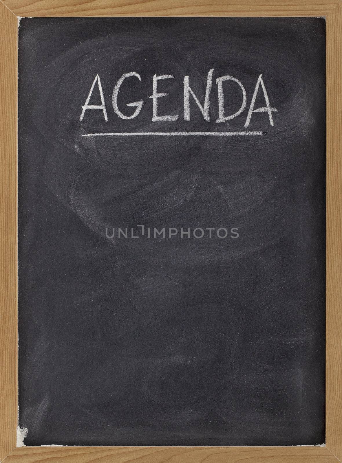 agenda - white chalk handwriting on blackboard with eraser smudges texture, copy space below