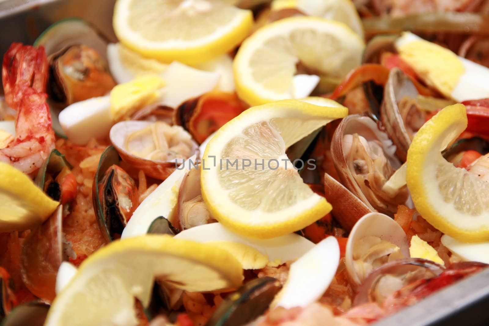 close-up of seafood paella with lots of lemon toppings
