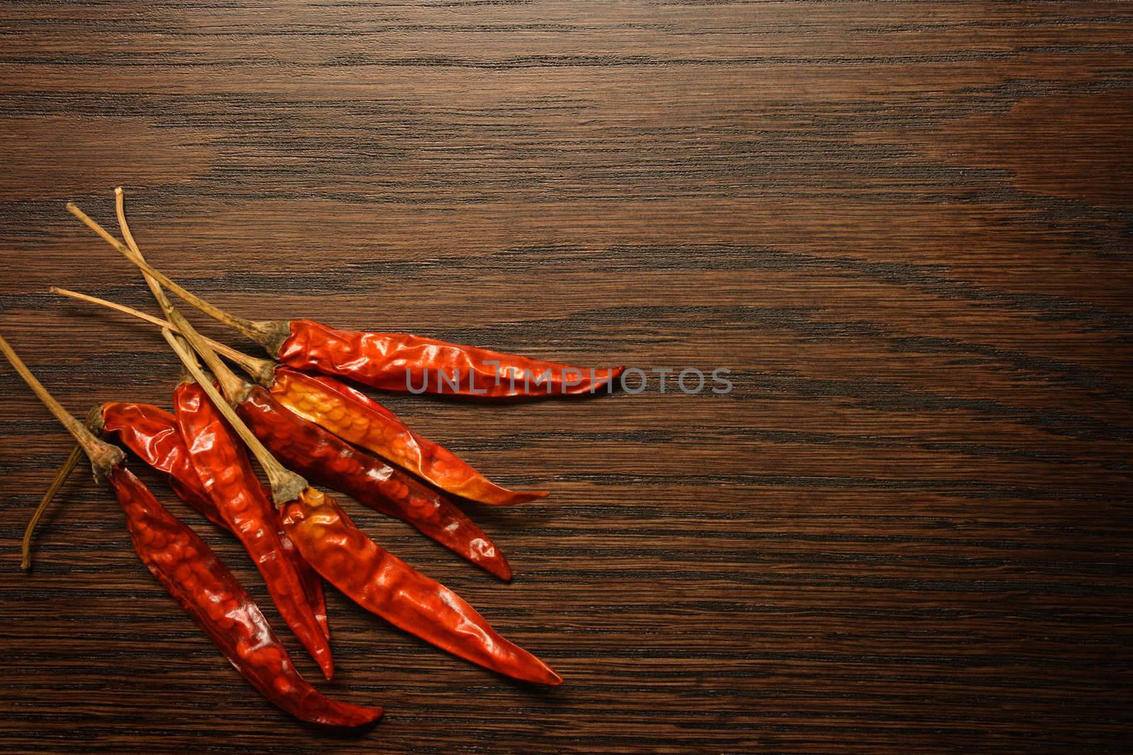 Dried red hot peppers sitting on a table top.  Lots of area for text.

