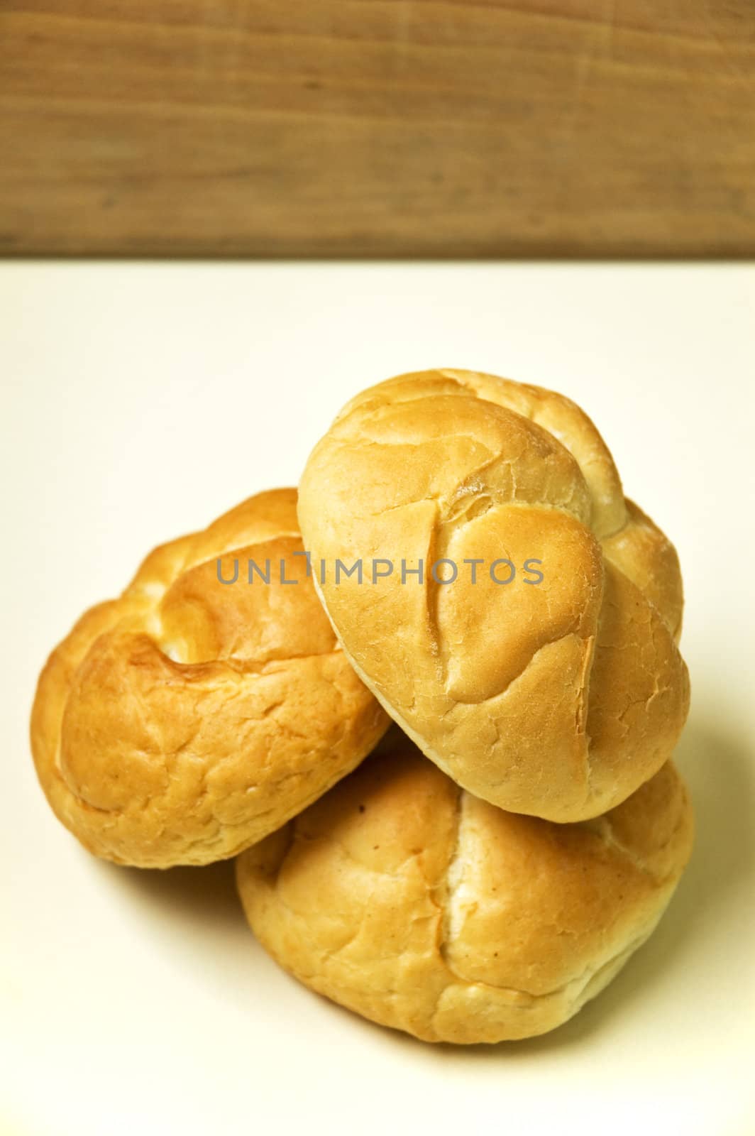 Three bread roll on kitchen table.
